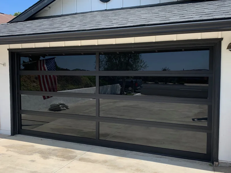 Full view black glass garage door installation in Laguna Beach CA
